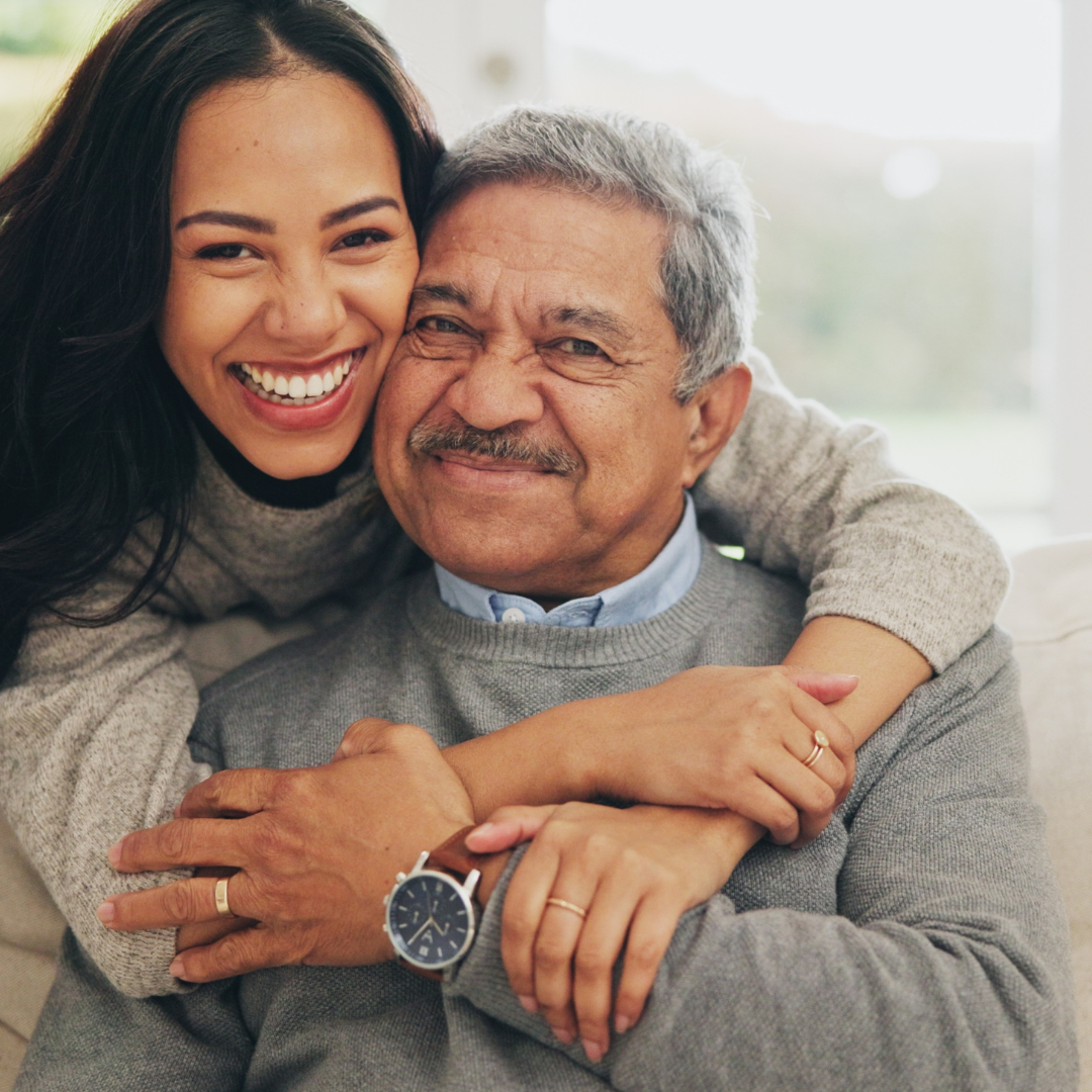 Adult daughter hugging her father and smiling