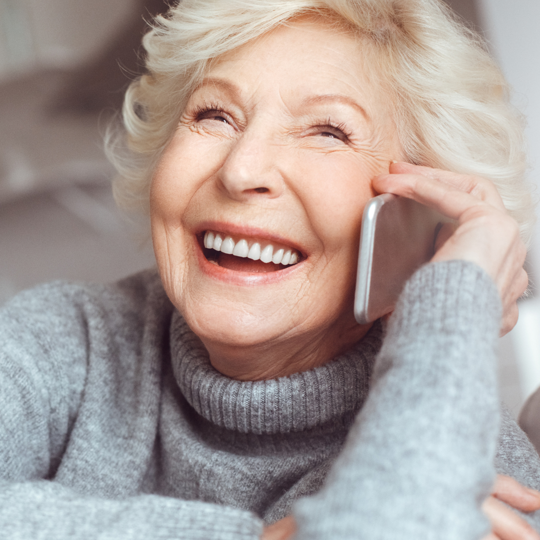 Smiling older adult enjoying a warm phone call